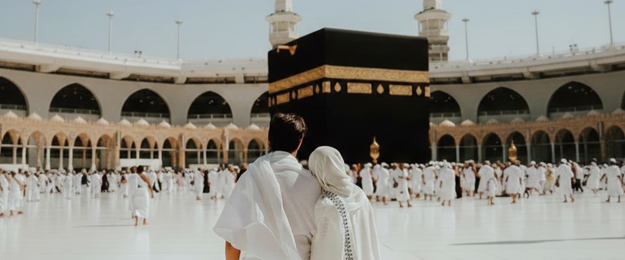 A couple standing together before the Kaaba in Makkah